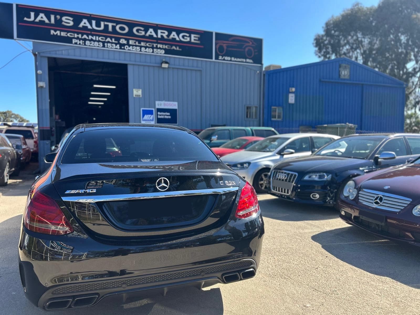 Jai's Auto Garage workshop exterior with customer vehicles parked outside